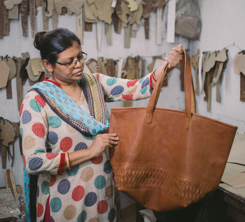 the mohinders leather shopper being held by one of the artisans who made it